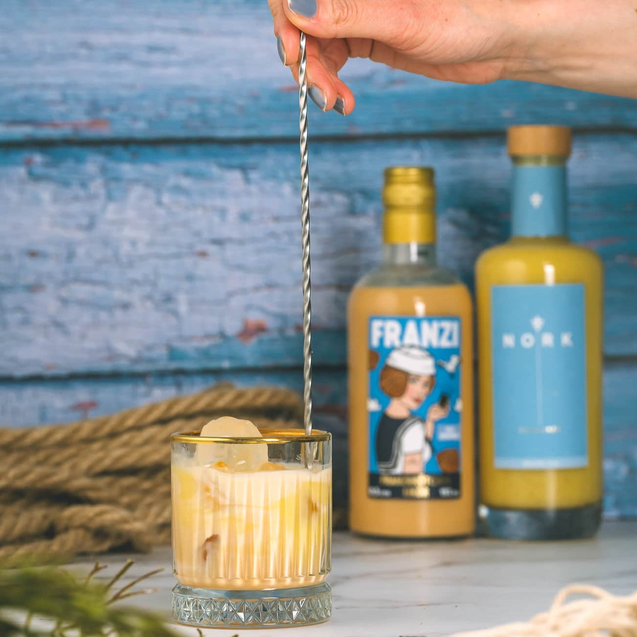Franzi Franzbrötchenlikör mit NORK Eierlikör in einem Glas mit Eiswürfeln